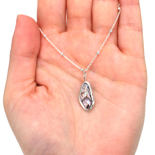 Abalone Shimmer Elongated Charm on model for color reference.
