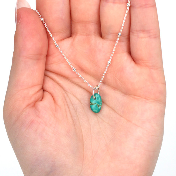 Turquoise Petite Drop Charm on model for color reference. 