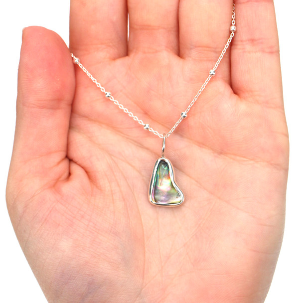 Abalone Charm on model for color reference.