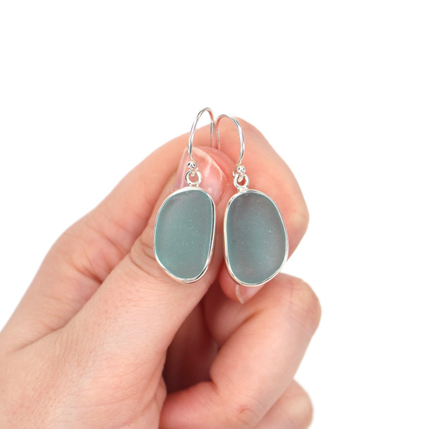 Aqua Oval Sea Glass Single Bezel Earrings on model for color reference.