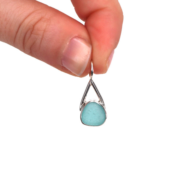 Aqua Gumdrop Sea Glass Lunar Drop Charm held to the light