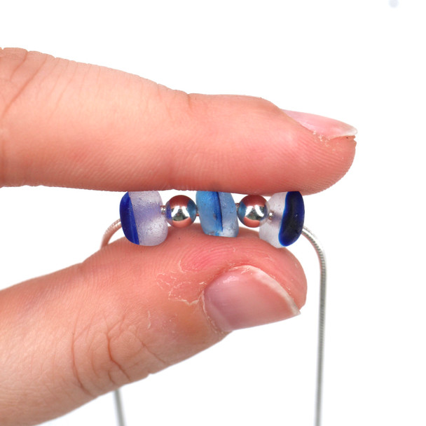 Blues Spotted Ultra Rare 3 Stone Necklace on Snake Chain held to the light