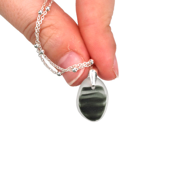 Gray Waves Ultra Rare Sea Glass Drop Necklace held to the light
