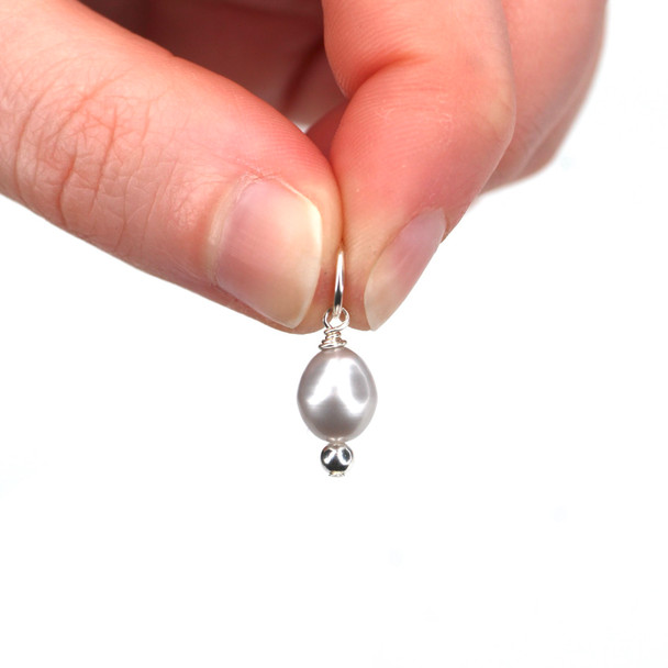 Gray Pearl Charm held to the light