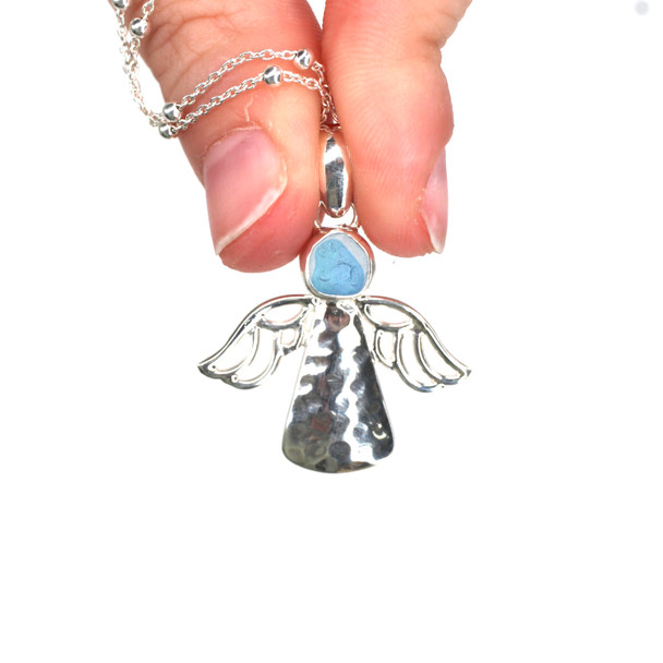 Turquoise Lagoon Spot Ultra Rare Sea Glass Angel Necklace held to the light