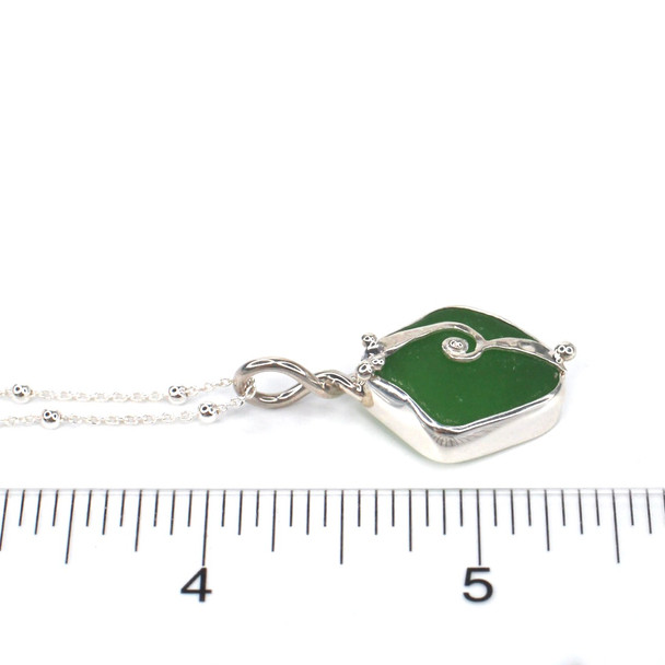 Green Sea Glass Wave Necklace on ruler for size reference. 
