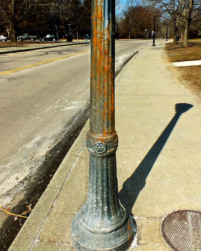 Steel light pole that is rusting and oxidizing.