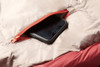 Close up of Kelty Cosmic 0 Sleeping Bag, red, showing phone partially extending from small zipper pocket