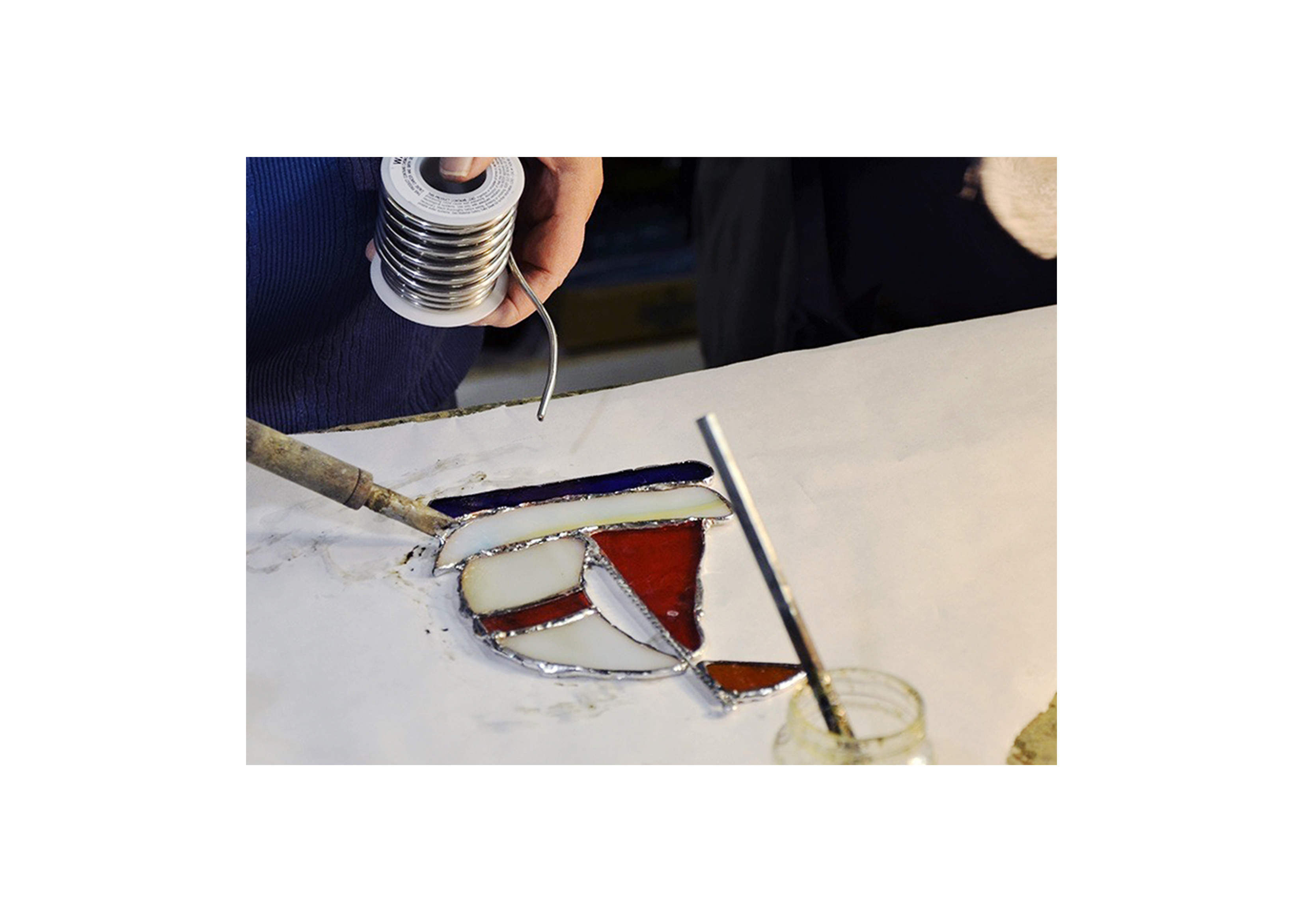a student working on a sailboat stained glass design