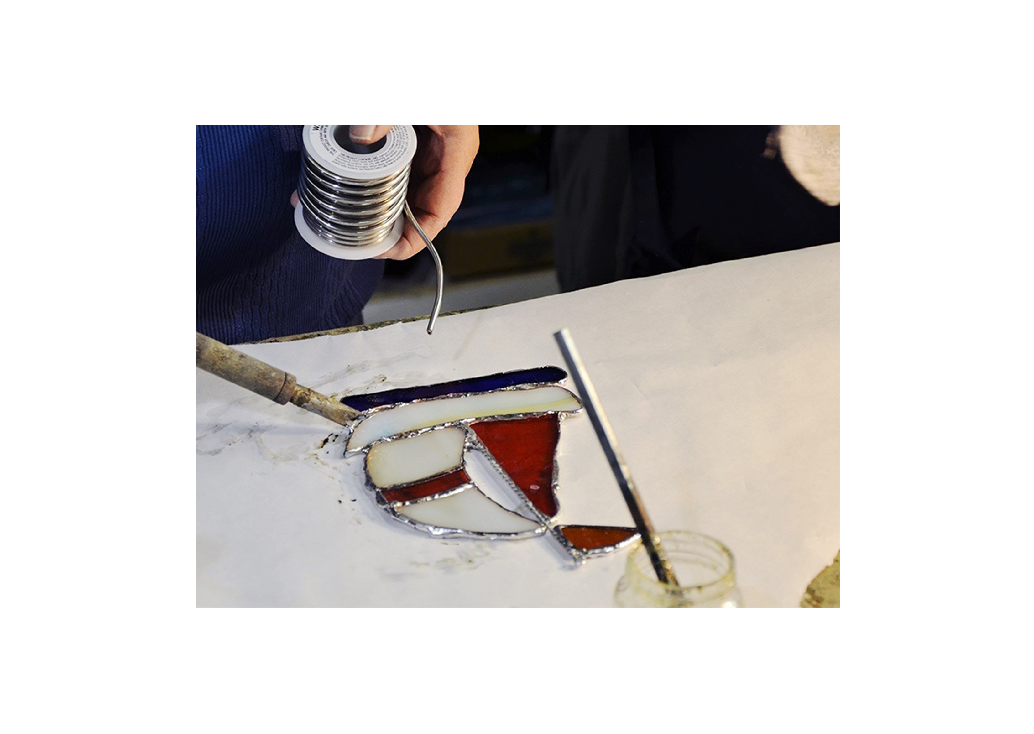 a student working on a sailboat stained glass design