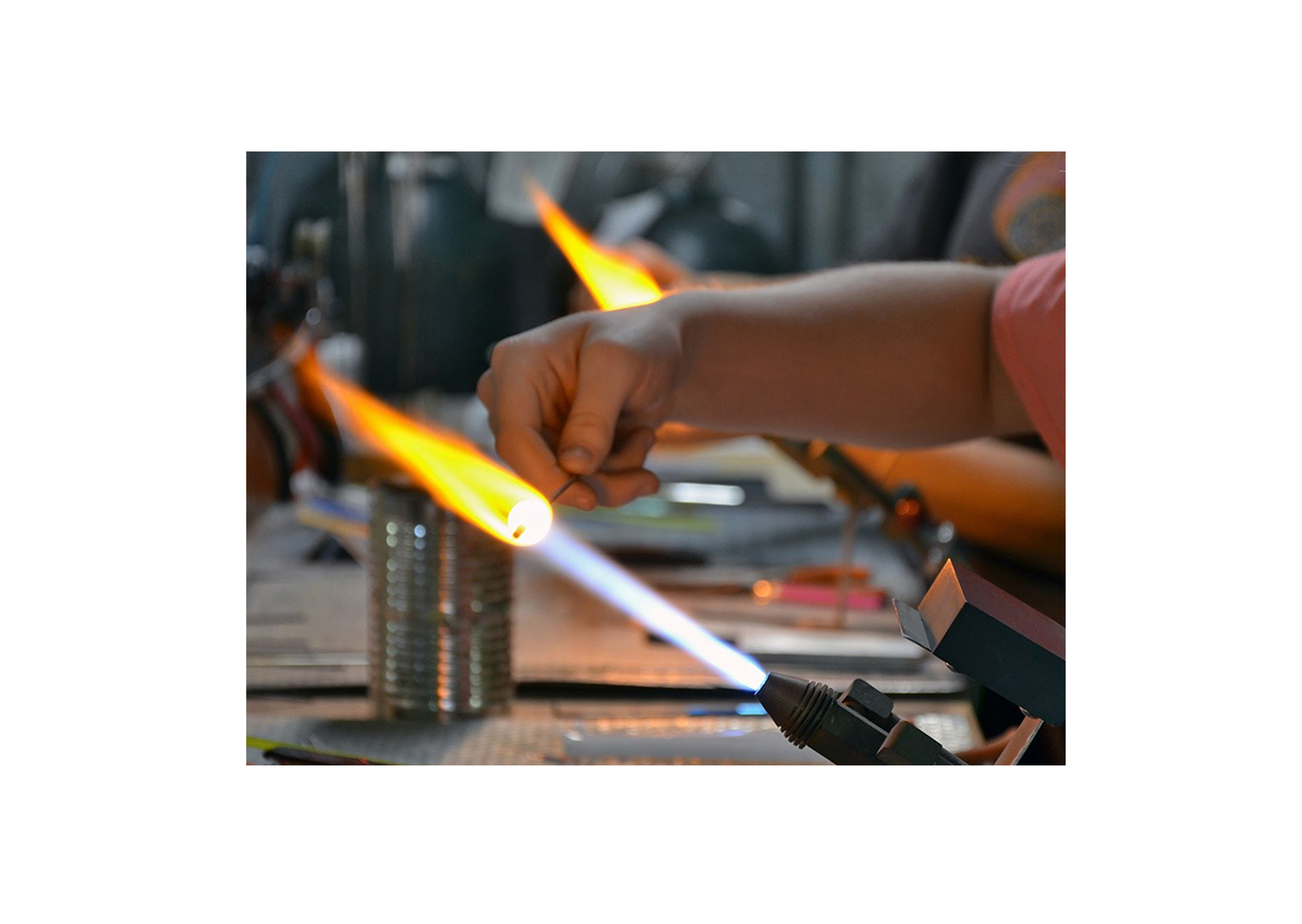 students working on glass beads with a torch