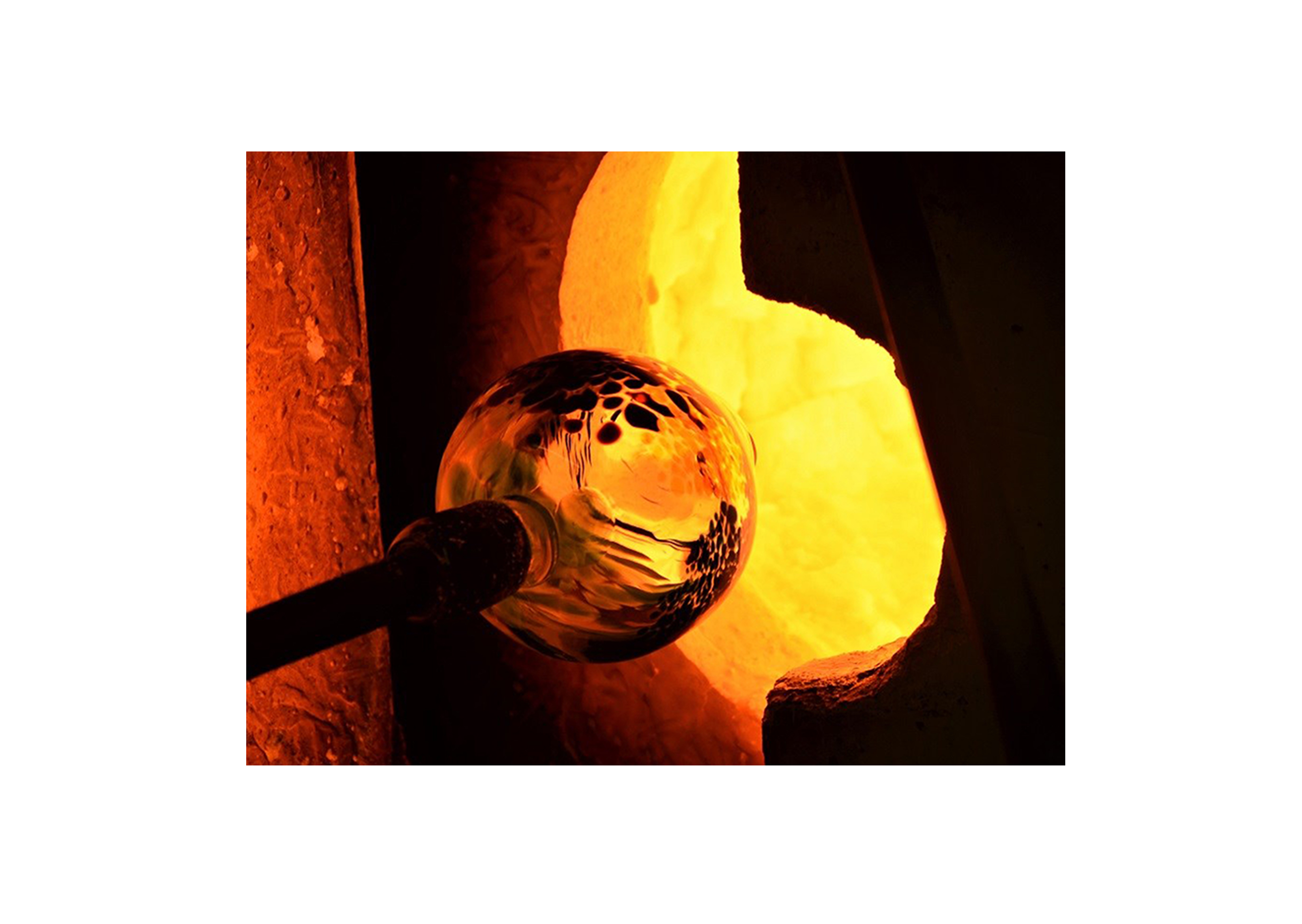 a hot glass blown piece going into a furnace