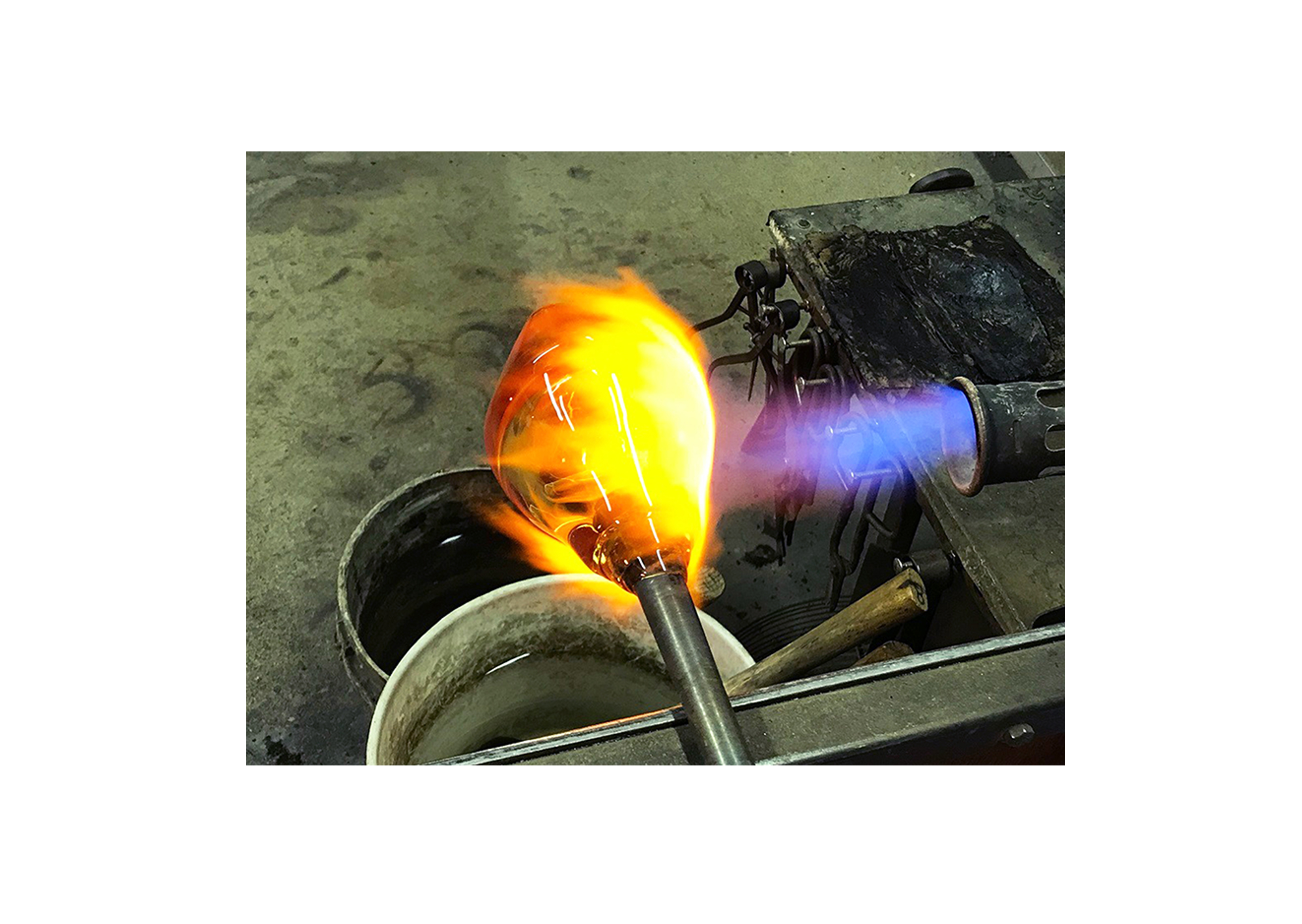 a hot glass blown piece under a flame