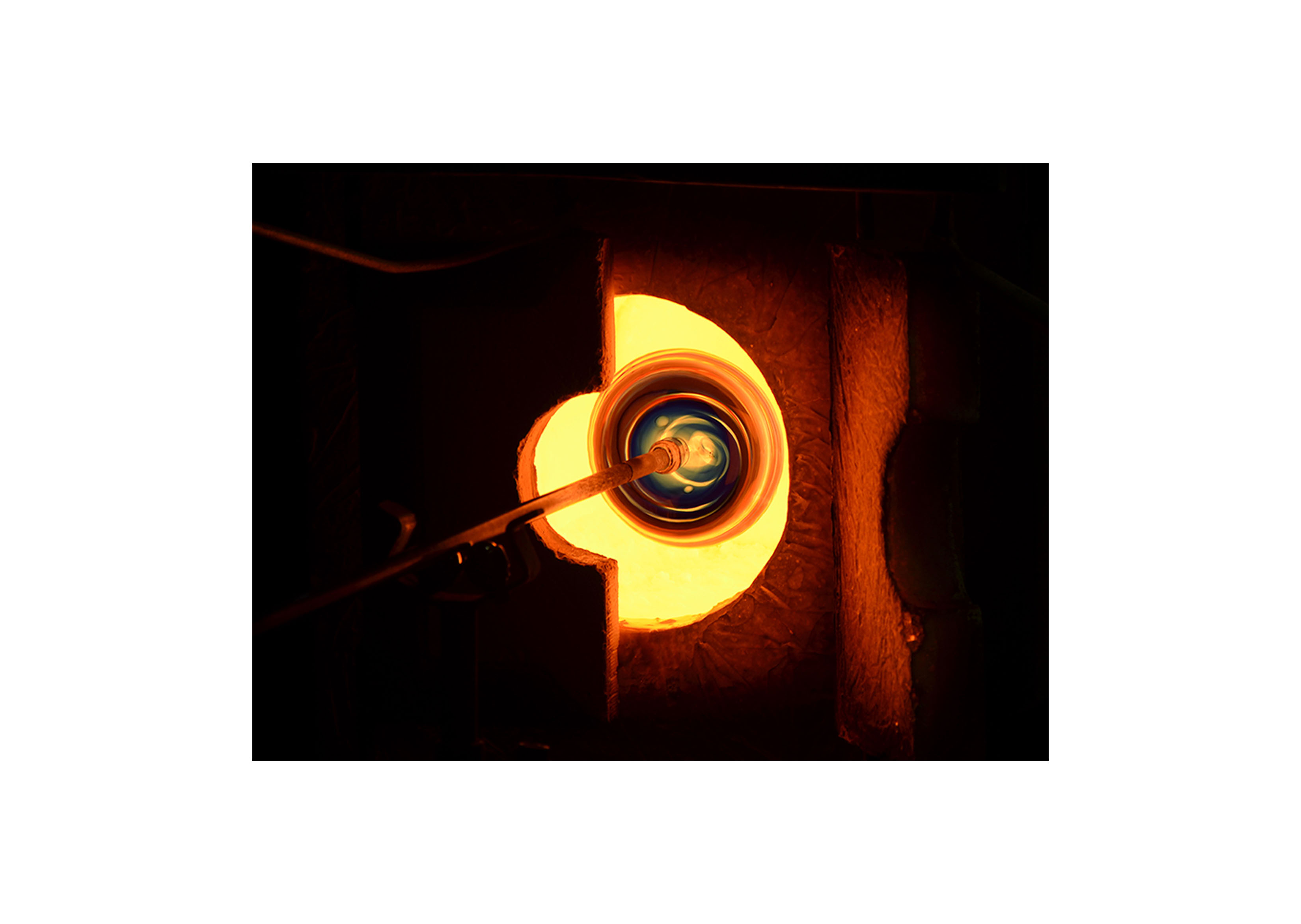 a piece of blown glass going into a furnace