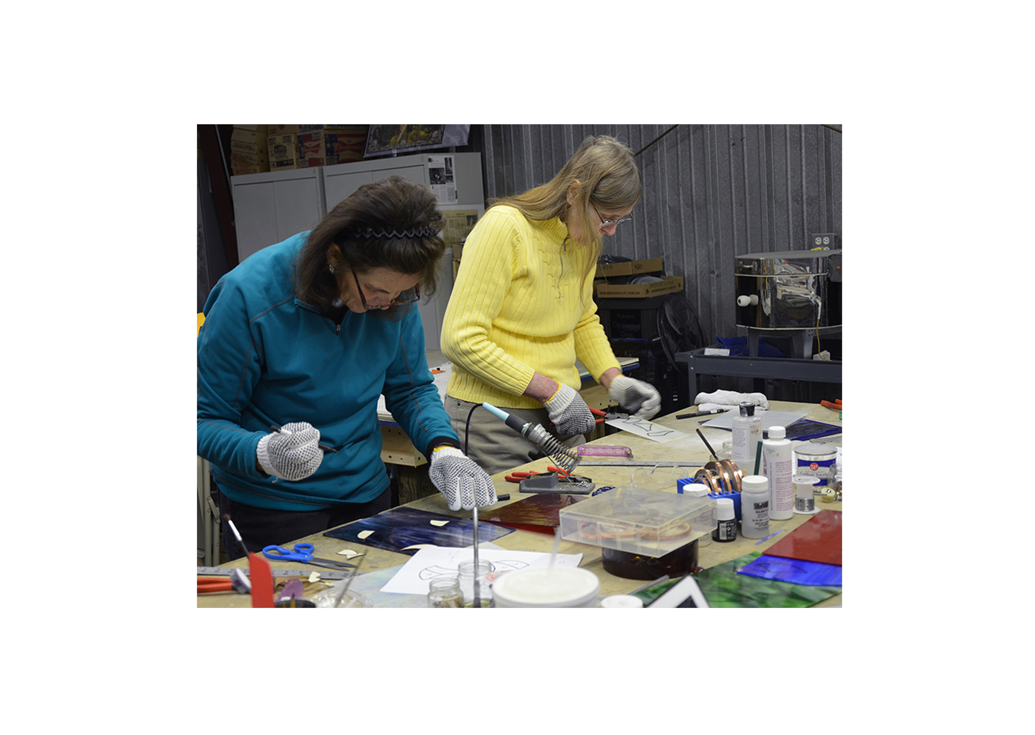 two students working on stained glass projects