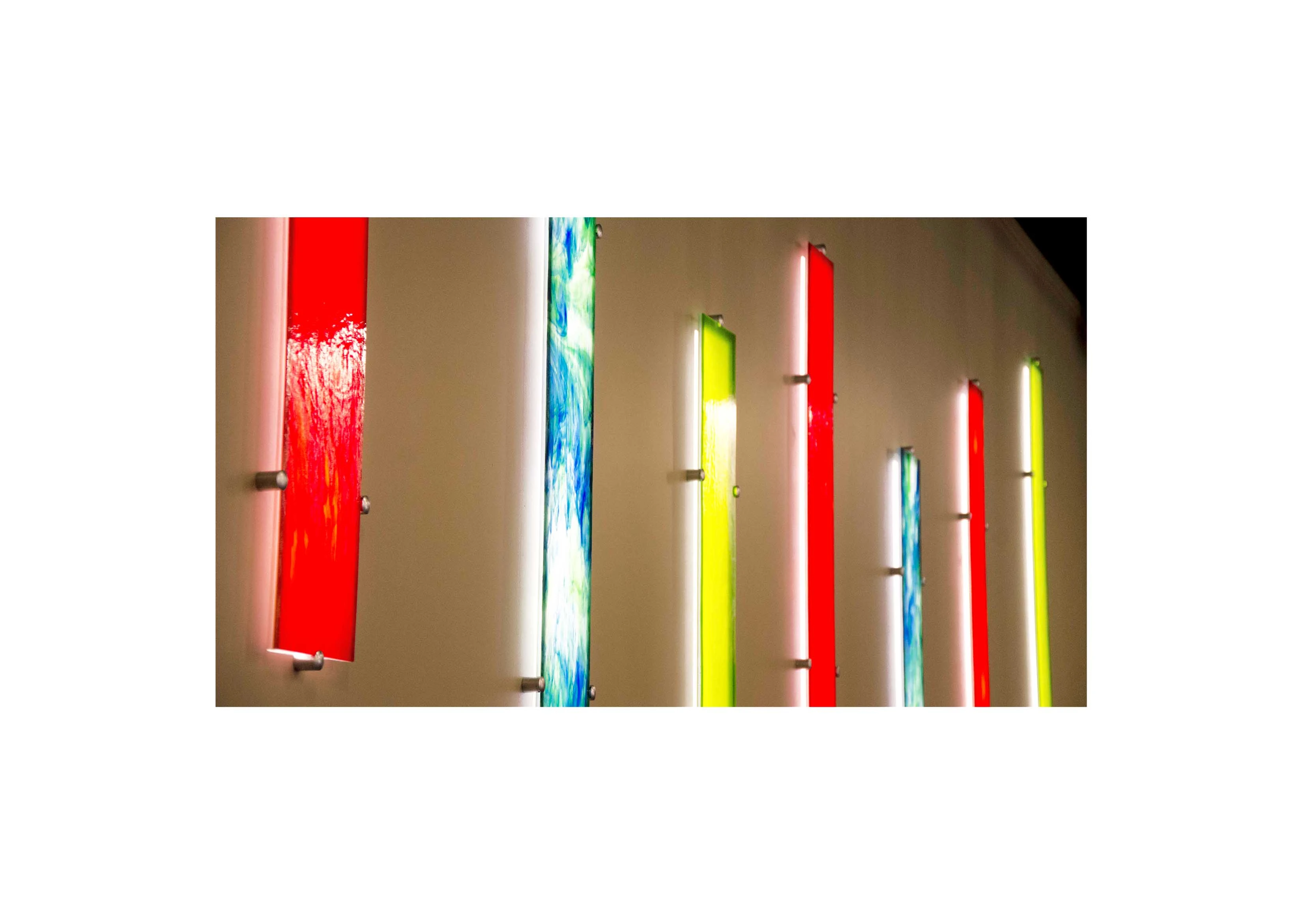 red, blue and yellow stained glass panels mounted on a wall