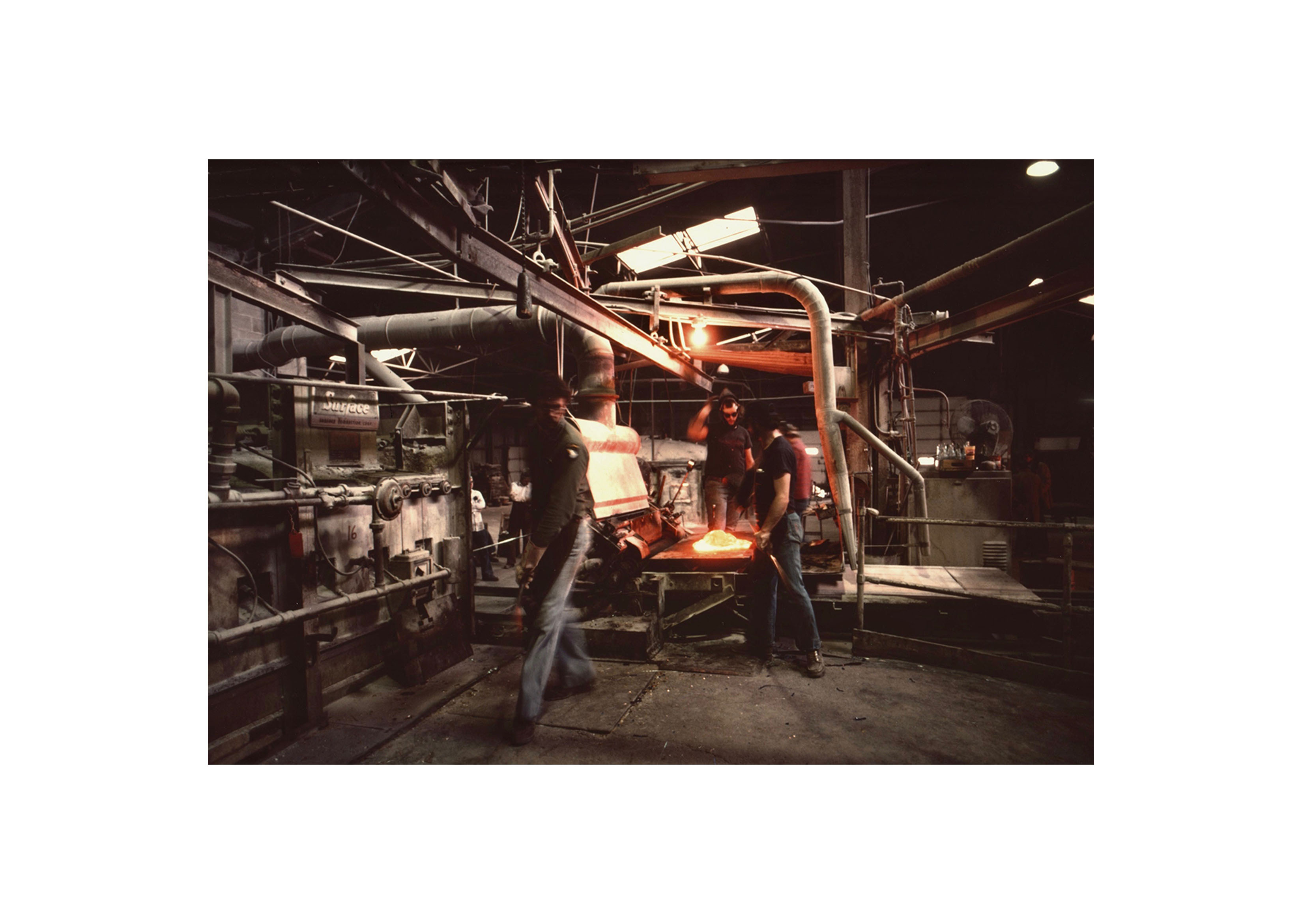 an image from the 1970's of three men working in the factory