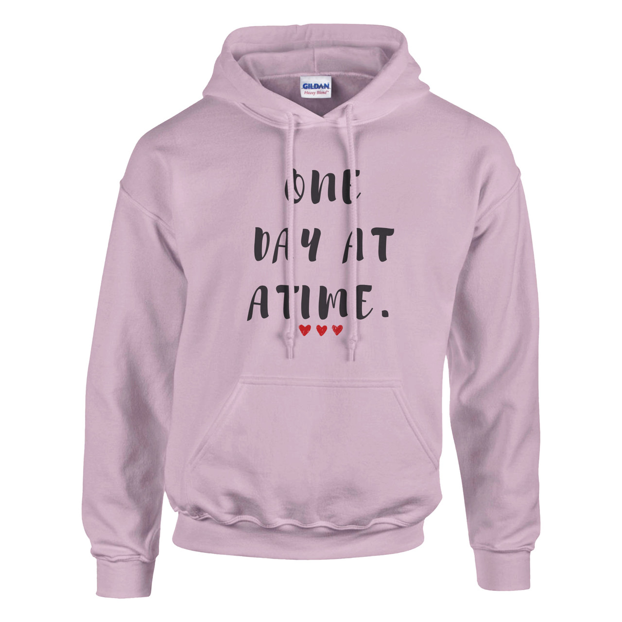 Light pink pullover hoodie displayed against a light gray background. The front features the uplifting message “ONE DAY AT A TIME.” in distressed black lettering, accented by three small red hearts beneath the text. The hoodie includes a drawstring hood, kangaroo pocket, and ribbed cuffs and hem. The soft pink color paired with the encouraging message creates a warm, supportive design that symbolizes hope, resilience, perseverance, and taking each day one step at a time. Ideal for cancer awareness, recovery journeys, mental health support, or everyday inspiration.