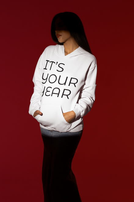 spotlight  styled  mockup  of  a  woman  posing  with  a  white gildan  hoodie with IT’S YOUR YEAR