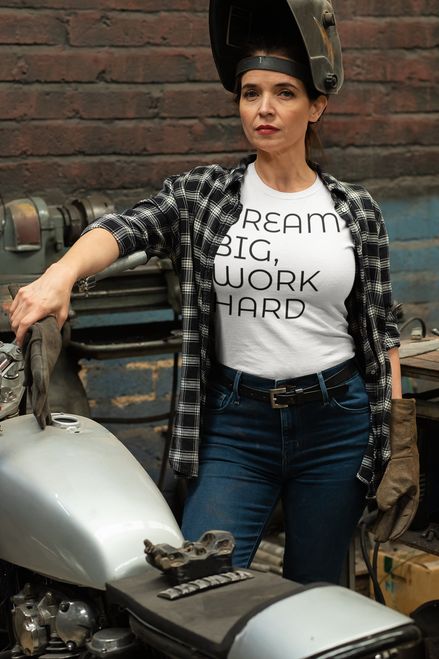 White t-shirt  mockup  of  a  woman  repairing  her  motorcycle with DREAM BIG, WORK HARD