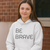 BE BRAVE Unisex Heavy Blend™ Hooded Sweatshirt Gildan 18500, woman in white