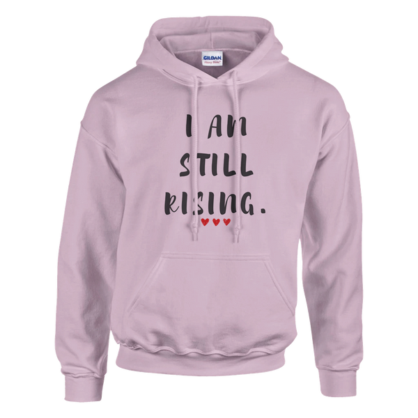 Women's light pink inspirational hoodie featuring the “I AM STILL RISING” graphic and red heart details. Motivational sweatshirt designed to encourage strength, empowerment, recovery, determination, and a positive mindset.
