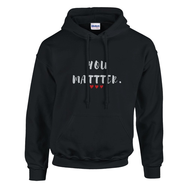 Black pullover hoodie featuring the uplifting phrase “You Matter” in distressed white lettering with three red hearts beneath. The hoodie includes a drawstring hood, front kangaroo pocket, and classic unisex fit. The inspirational design promotes self-worth, encouragement, hope, and positive mental well-being.