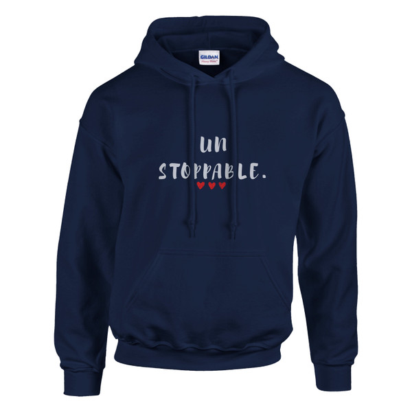 Navy blue pullover hoodie displayed against a light gray background. The front features the empowering message “UNSTOPPABLE.” in distressed white lettering, with the word split across two lines and accented by three small red hearts beneath the text. The hoodie includes a drawstring hood, spacious kangaroo pocket, and ribbed cuffs and hem. The deep navy color provides a classic, versatile look while creating strong contrast for the design. The message symbolizes determination, resilience, confidence, and perseverance, making it an ideal choice for cancer awareness, recovery journeys, personal growth, and everyday motivation.
