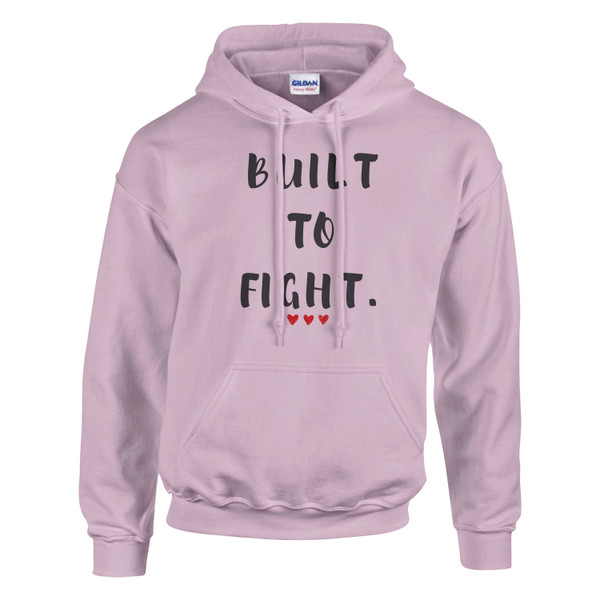 Light pink pullover hoodie featuring the inspirational quote “Built to Fight” in distressed black lettering with red heart accents, displayed on a plain background.