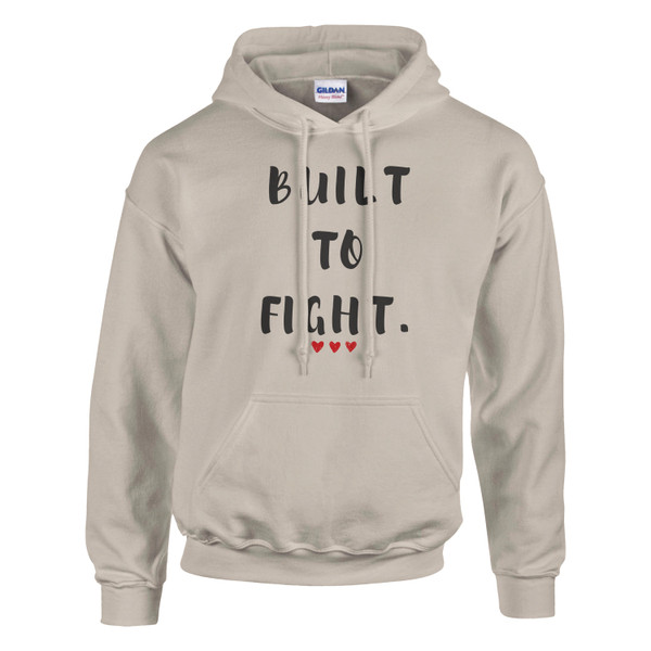 Sand-colored pullover hoodie featuring the inspirational quote “Built to Fight” in distressed black lettering with red heart accents, displayed on a plain background.