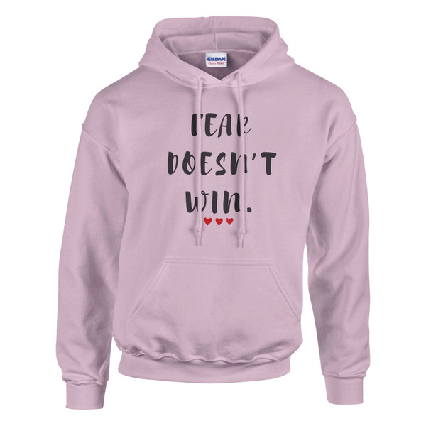 Pink hoodie featuring the motivational quote “FEAR DOESN’T WIN” in black lettering with three red hearts, symbolizing courage, resilience, hope, empowerment, positive mindset, and overcoming fear.