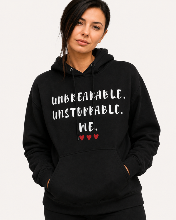 Woman wearing a black hoodie featuring the inspirational quote “Unbreakable. Unstoppable. Me.” with red heart accents, motivational apparel designed to inspire confidence, strength, resilience, and self-empowerment.