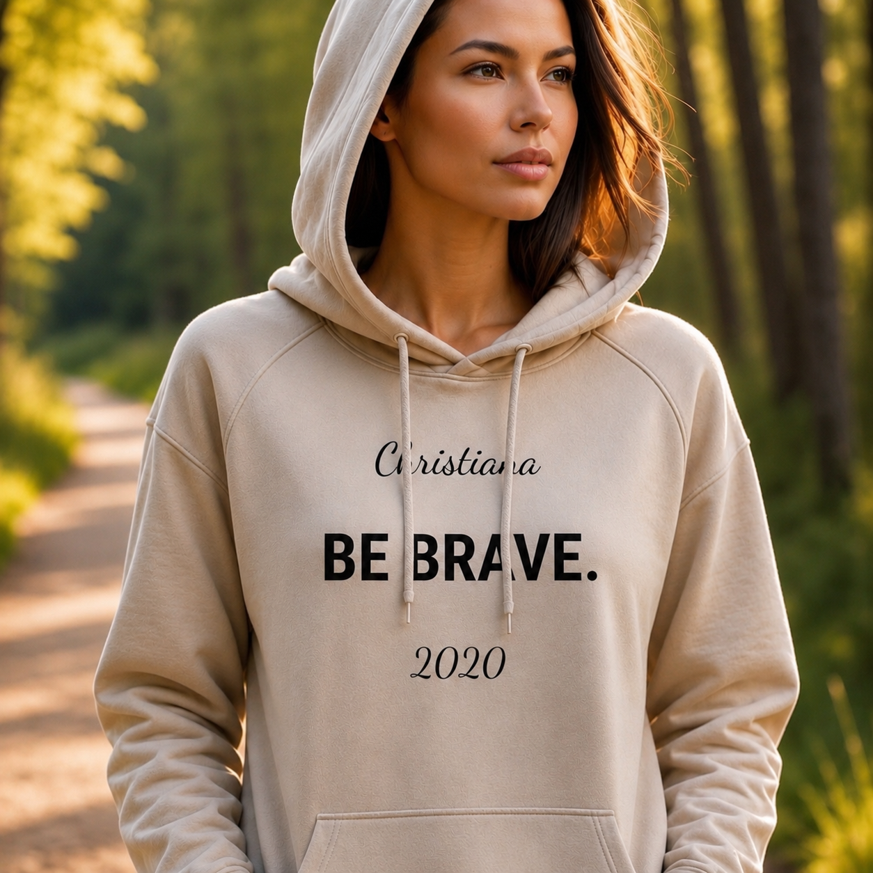 Woman with sand colered hoodie over her head; BE BRAVE. text, Christiana and 2020 above and below quote