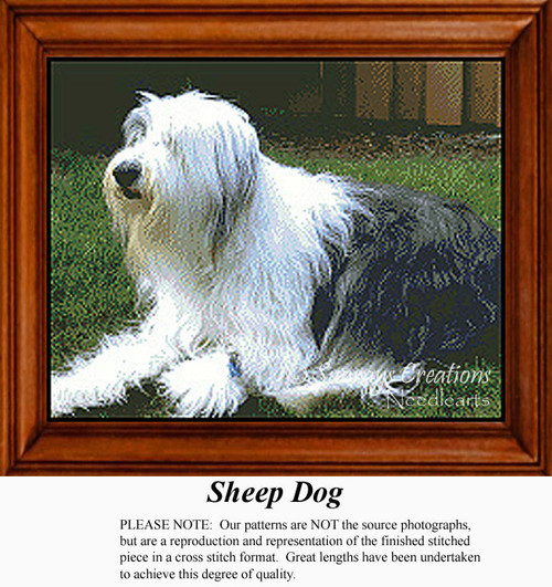 A large, relaxed sheep dog lies on green grass, framed in a wooden border, presented as a colorful cross stitch kit for animal lovers.