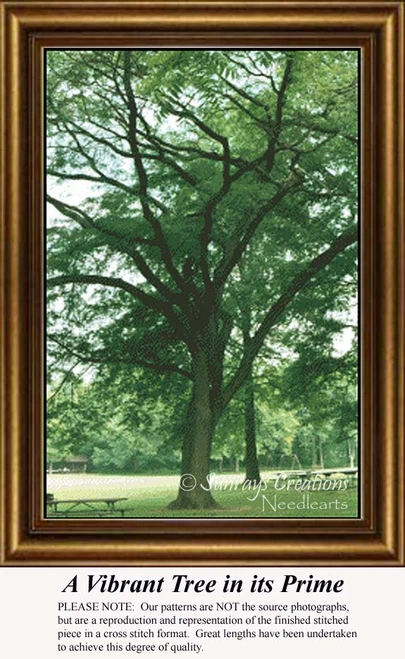 A large tree with fern-like leaves stands in a park setting, framed above text that introduces this downloadable pattern for cross stitch enthusiasts.