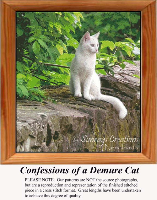 A white cat sits on a stone wall surrounded by green foliage, preserved as a counted cross stitch pattern.