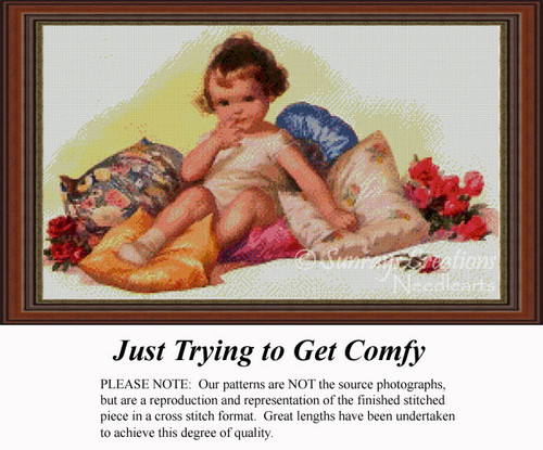 An adorable little girl sits on colorful pillows, looking cozy and ready to nap, designed as a large cross stitch pattern for relaxing projects.