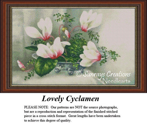 A vase filled with white and blush cyclamen flowers and green leaves, translated into a counted cross stitch design.