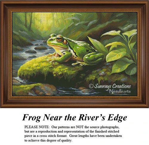 A green frog rests on a mossy stone by a stream, surrounded by leafy vegetation, depicted in a cross stitch project by Sunrays Creations.