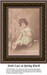 A girl sits on a knoll in the woods, surrounded by pale pink flowers, reimagined as a counted cross stitch pattern.
