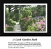 A detailed counted cross-stitch pattern preview of the piece "A Lush Garden Path." The Impressionist botanical landscape design features a sunlit gravel path curving past vibrant beds of blooming pink, purple, and yellow flowers, capturing floral abundance.
