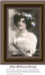 A woman with thick brown hair adorned with blue ribbons smiles softly while wearing a white fur stole, yours to stitch as a counted cross stitch.