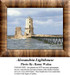 A lighthouse stands on a rocky outcrop surrounded by water, perfect for a cross stitch project inspired by the Alexandria Lighthouse.