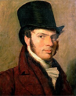 A self-portrait painting of the artist Jacques-Laurent Agasse. He is shown from the chest up with short, dark hair and a clean-shaven face. He wears a dark, high-collared jacket typical of the early 19th-century Regency era. His gaze is direct and observant, reflecting the precision and focus characteristic of his renowned animal and landscape paintings.