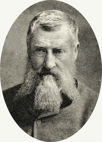 A black and white, formal portrait photograph of the German painter Hermann Kauffmann (1808–1889), showing a distinguished older man with a long beard and dark jacket.