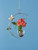 Crescent hanging rooting vase with Brass Butterfly accent and handblown glass vase with flower stems in water on a blue background
