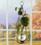 Dimensional teardrop hanging rooting vase with Brass Butterfly accent, handblown glass, and copper-coated finish with pothos plant cutting in window