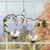 Double heart hanging vase displayed in window with trailing greenery