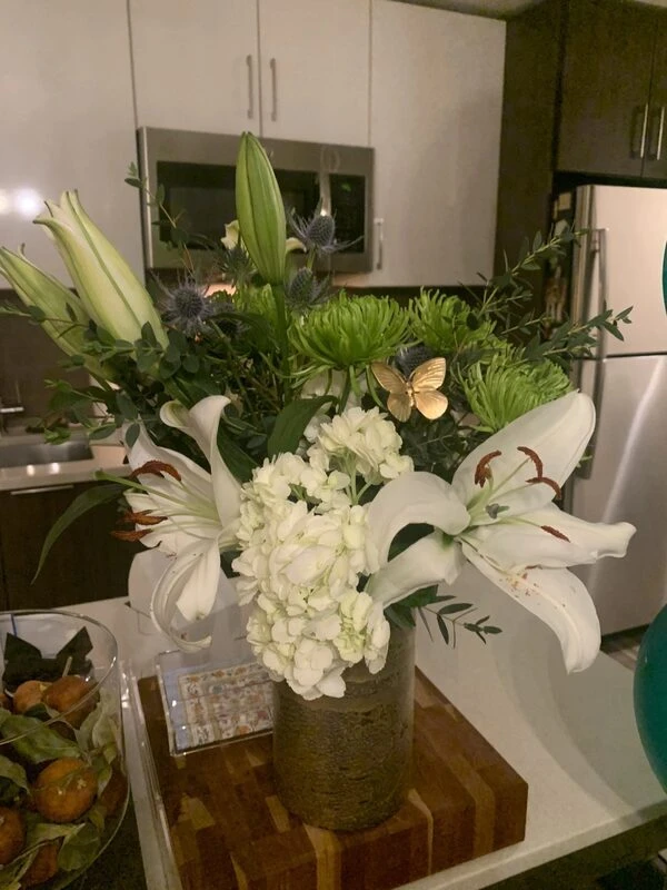 White and green flower arrangement accented with a Brass Butterfly plant stick