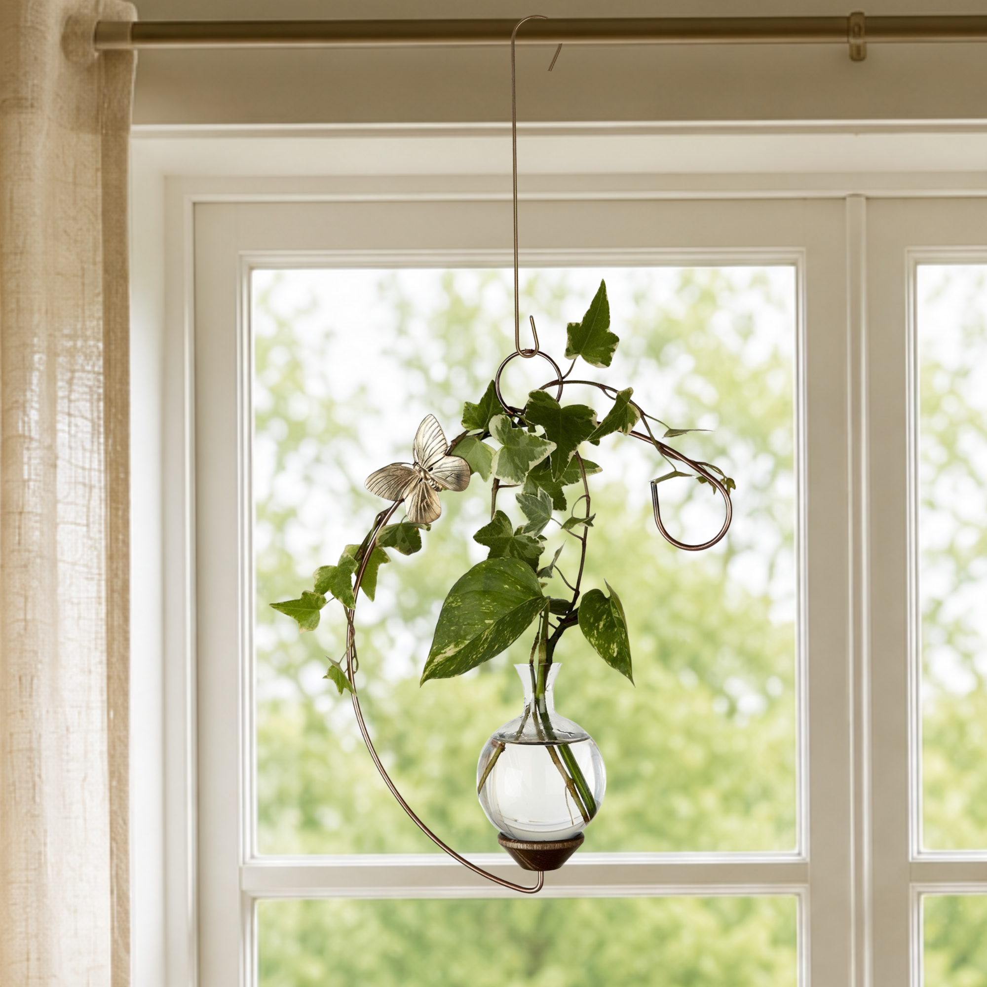 Handcrafted crescent hanging propagation vase with hand-blown glass and plant cutting in window